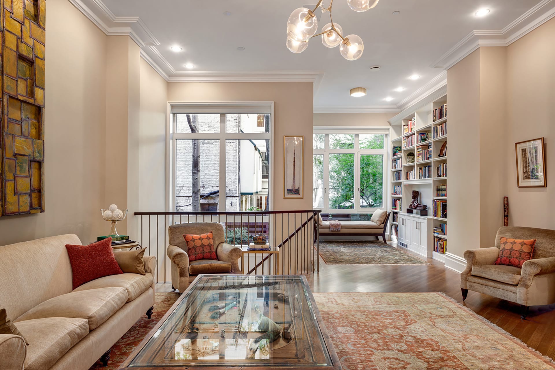 Living space with two separate seating areas, a coffee table that doubles as a display case, and antique rugs.