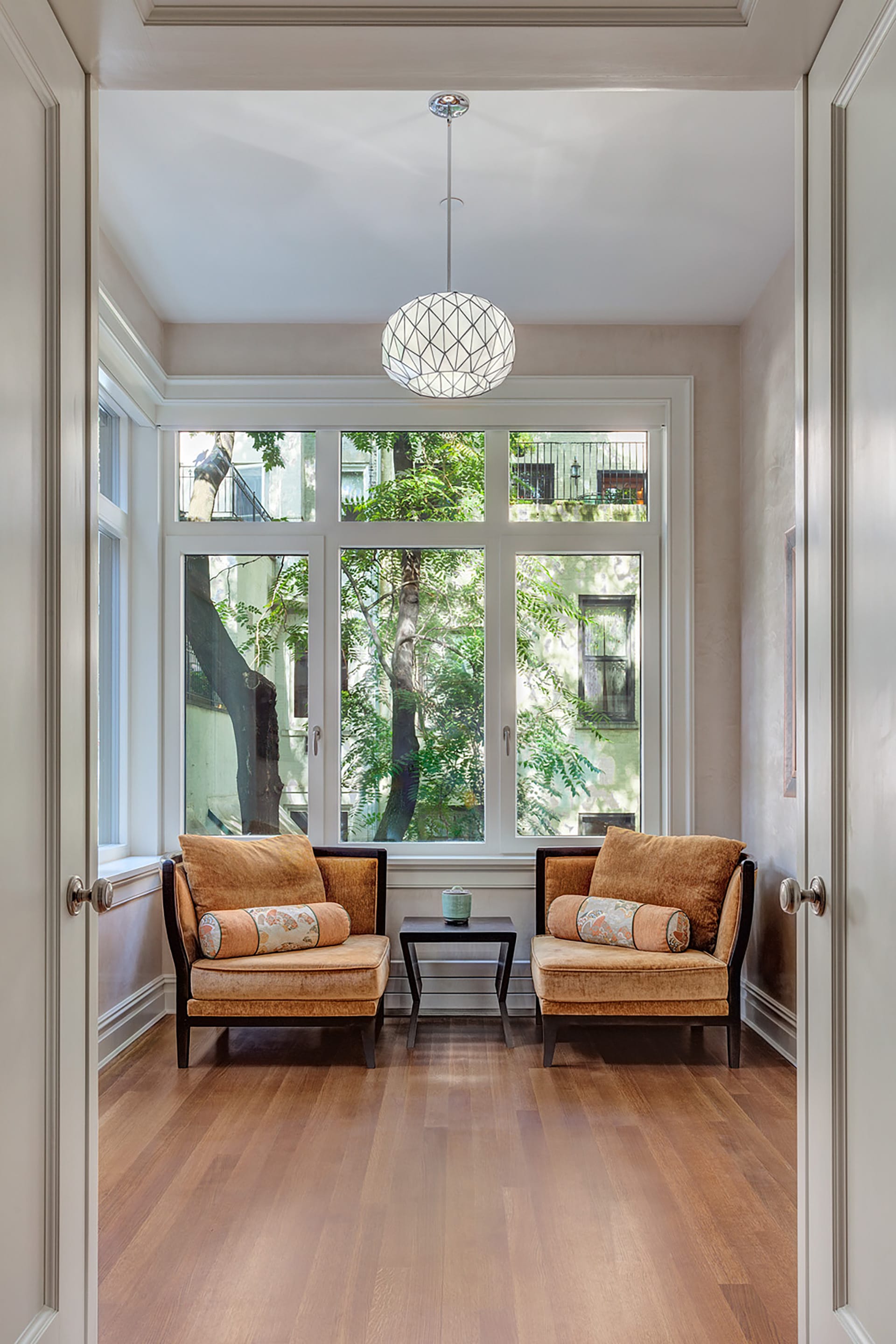 Seating area with two armchairs and wraparound windows.