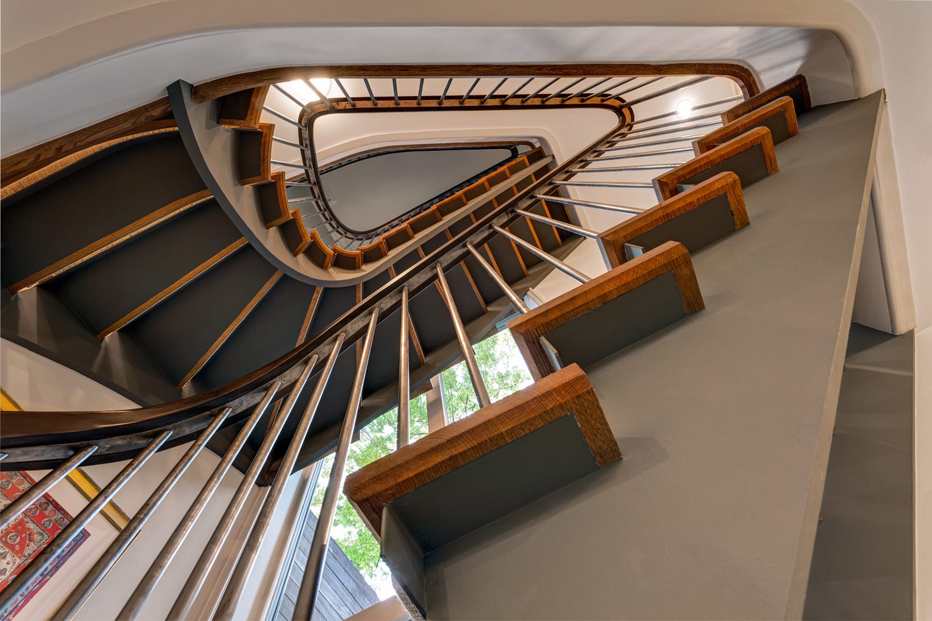 View from the bottom looking up at an open stringer, open riser sculptural staircase