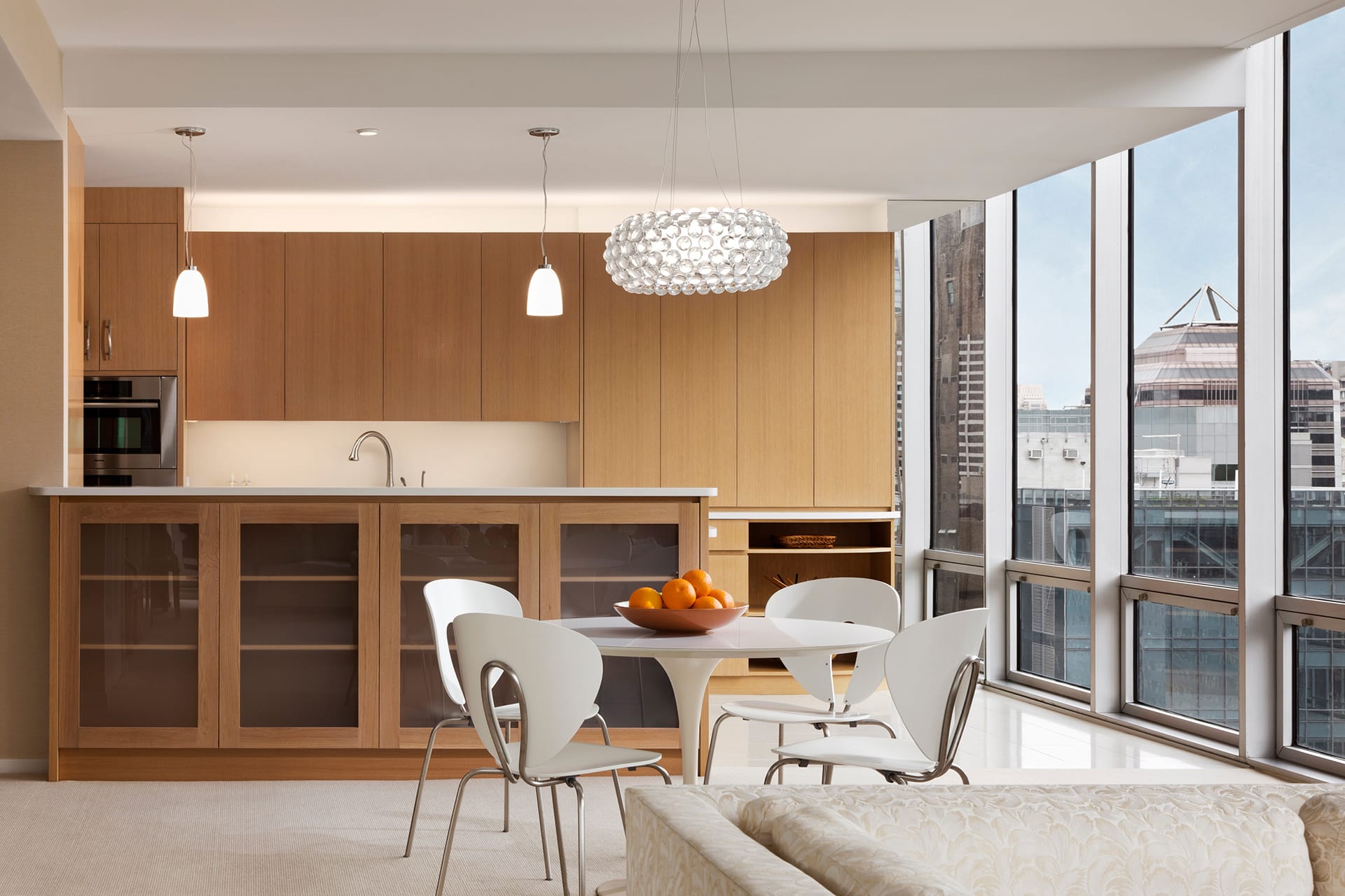 Kitchen with a white island, large floor tiles, and light wood cabinetry.