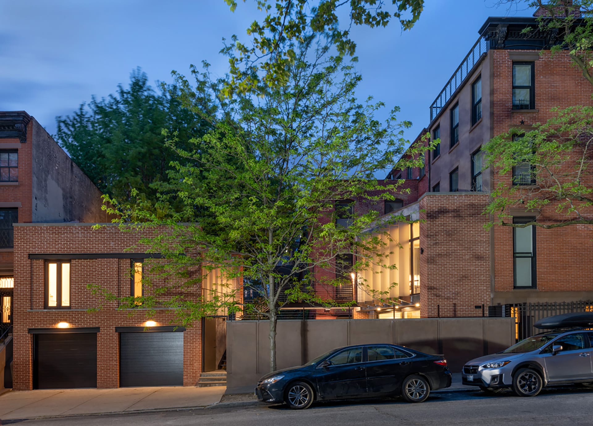 Side view of a Park Slope corner home with a four-story townhouse, two-story detached rear garage, and courtyard in between after our renovation