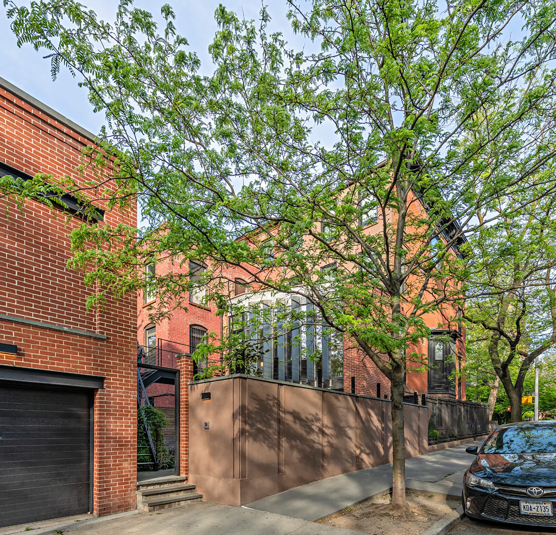 Street view of a Park Slope corner home with the rear façade of the four-story townhouse visible