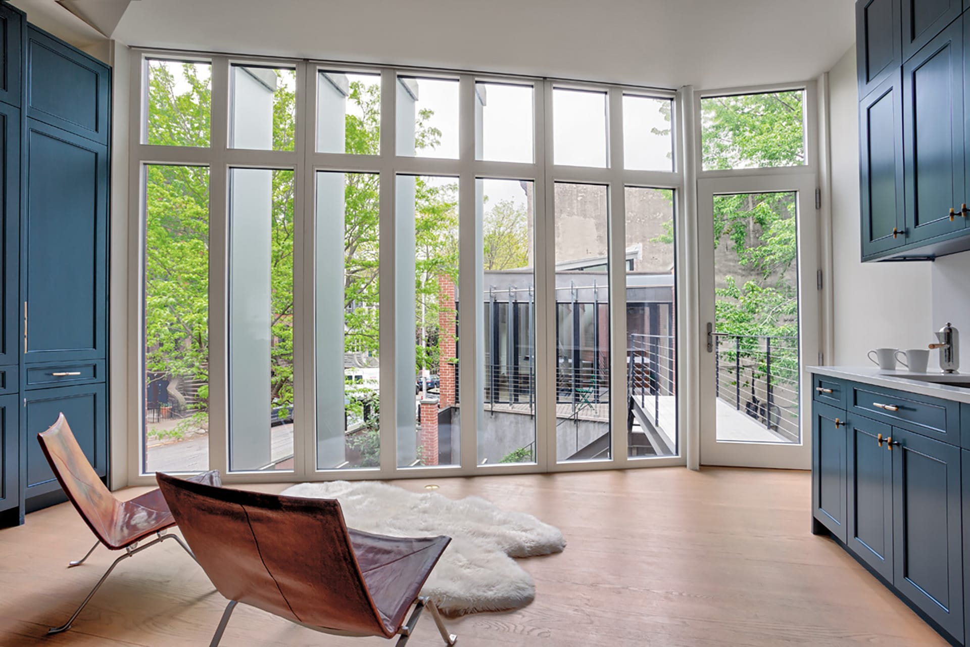 Seating area with blue millwork, wood floors, and floor-to-ceiling windows