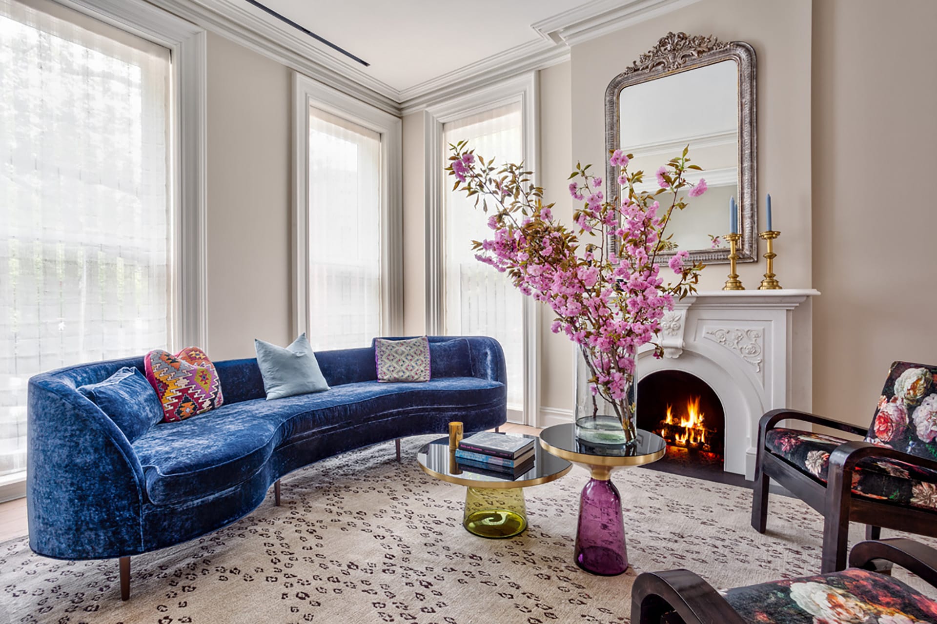 Living room in a Park Slope home with a fireplace, blue velvet couch, and two floral armchairs