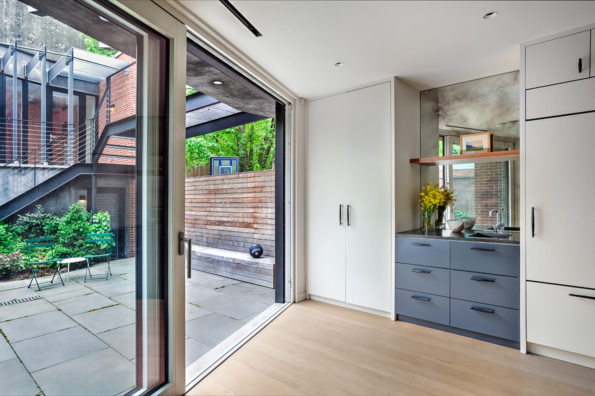 Large sliding glass doors leading out to a courtyard in a Park Slope home in a garden-level entertainment room.