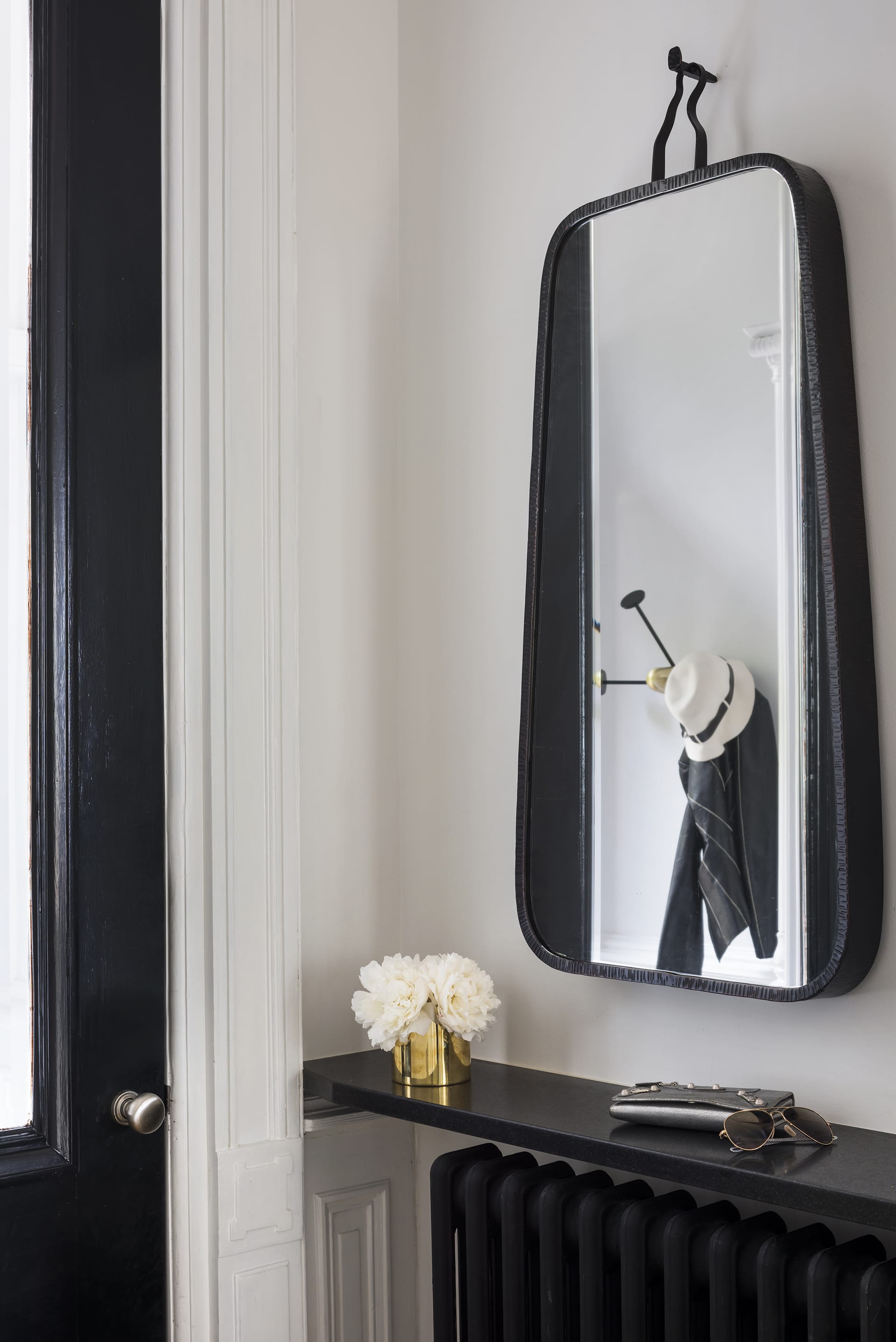 Entryway of a Prospect Heights home with a black mirror next to the black front door
