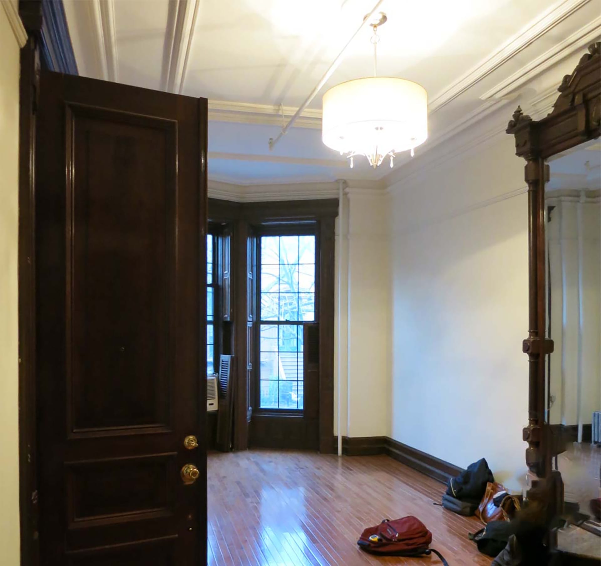 Living room in a Prospect Heights home with dark wood accents and a large vintage wood mirror