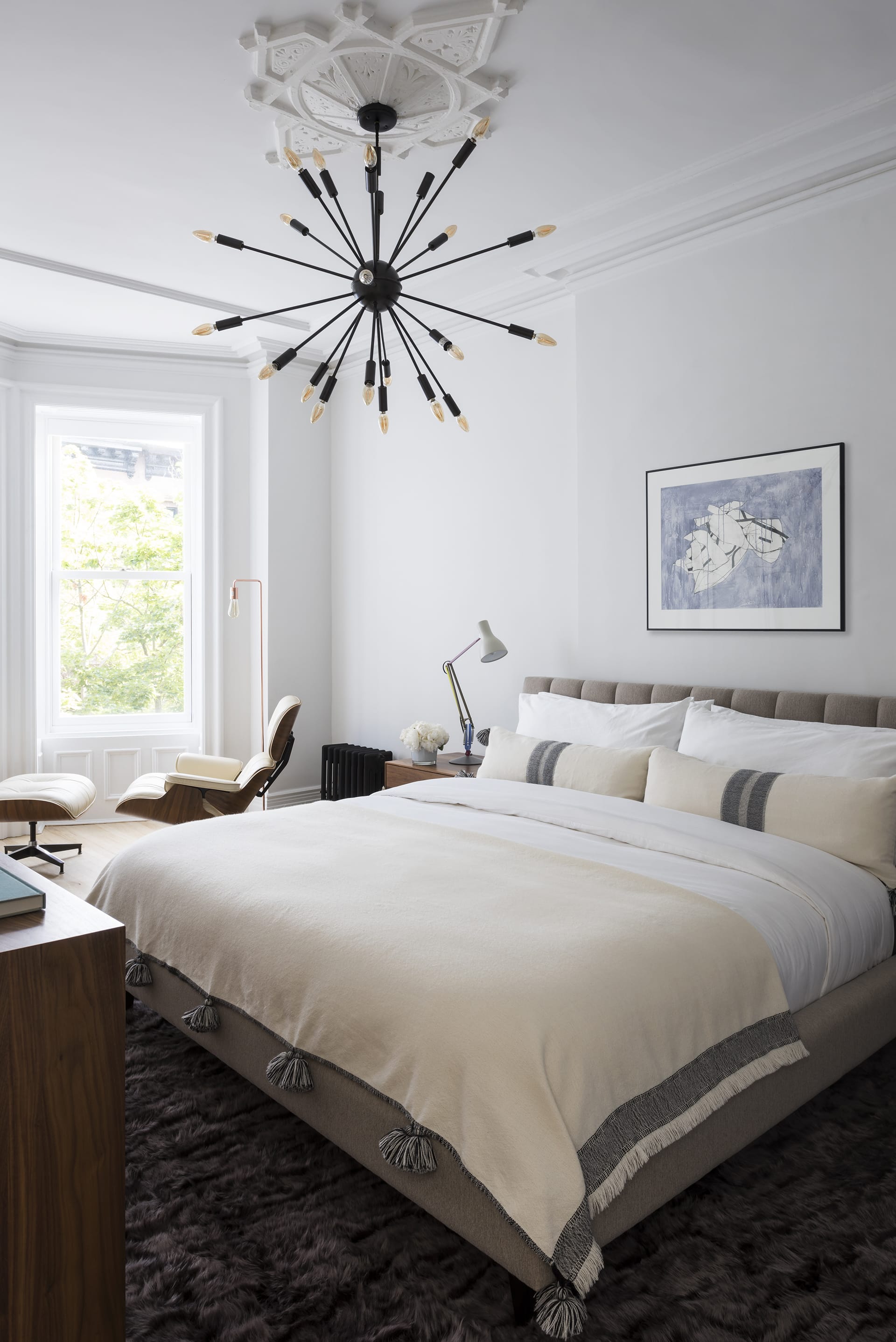 Bedroom in a Prospect Heights home with plaster detailing on the ceiling and a black chandelier.