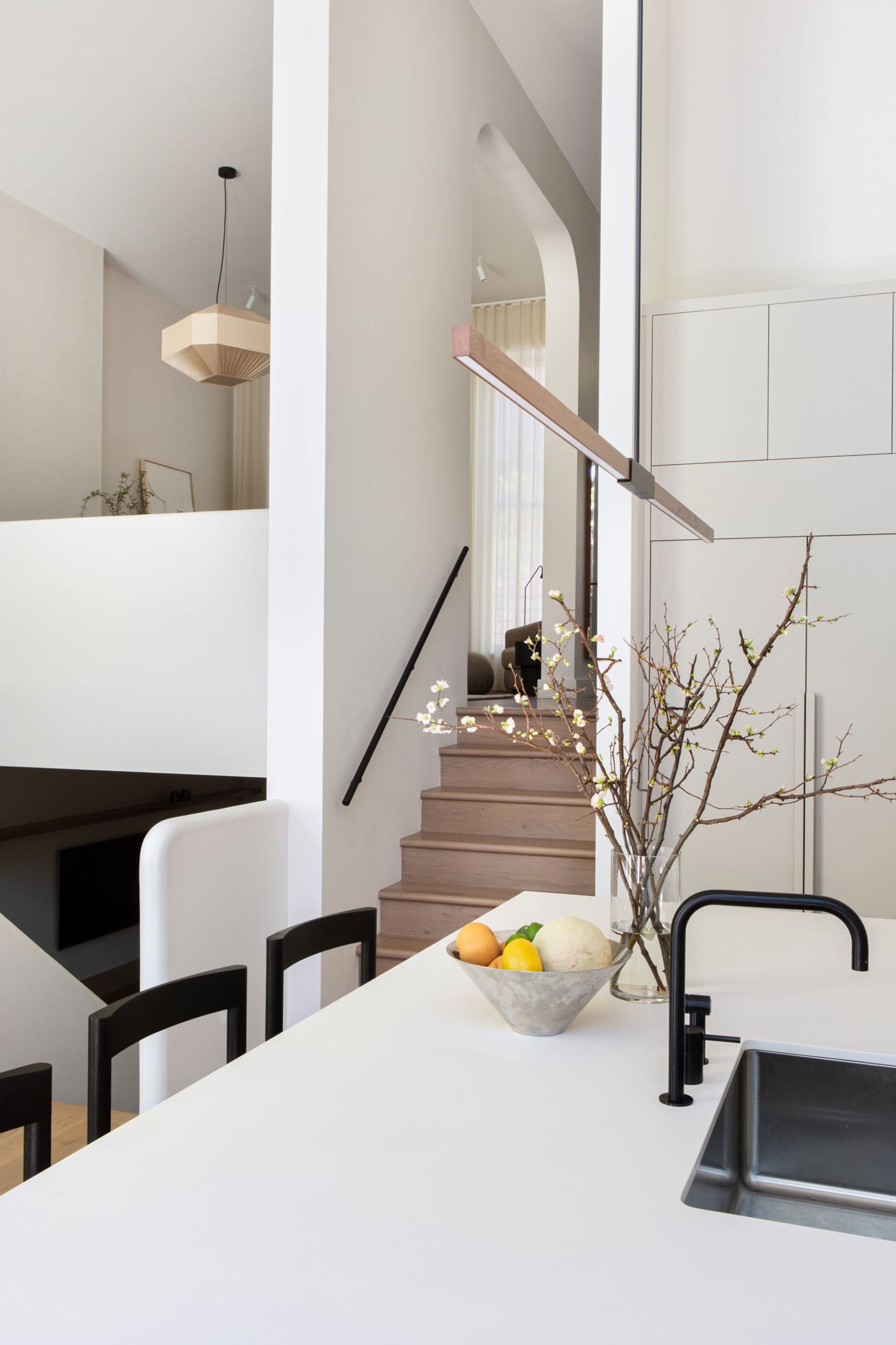 View from the kitchen into the front of a townhouse, with a split level housing two separate living spaces.