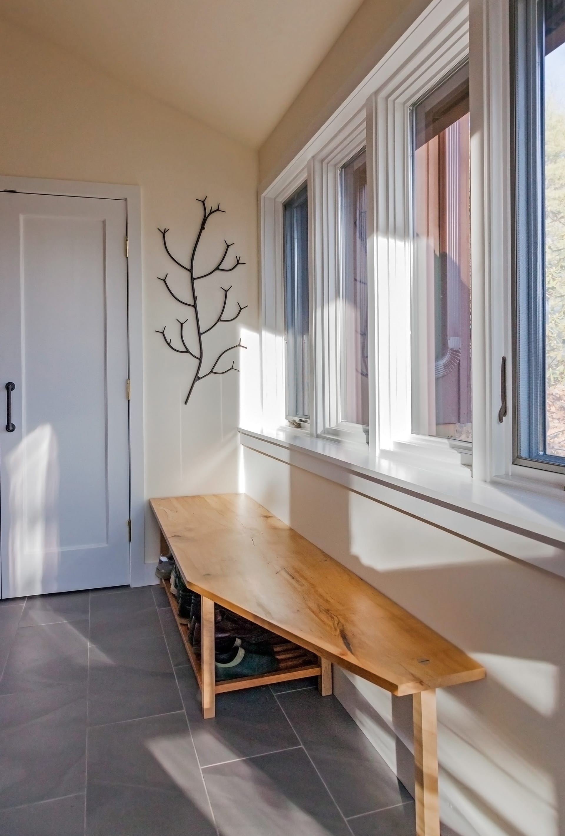 Wood bench in front of four casement windows