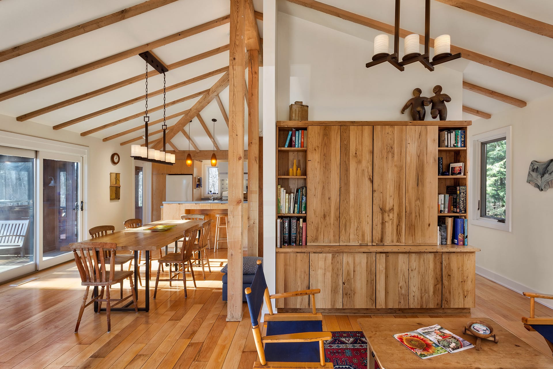 Open living space with wood floors, exposed ceiling beams, and wood furnishings