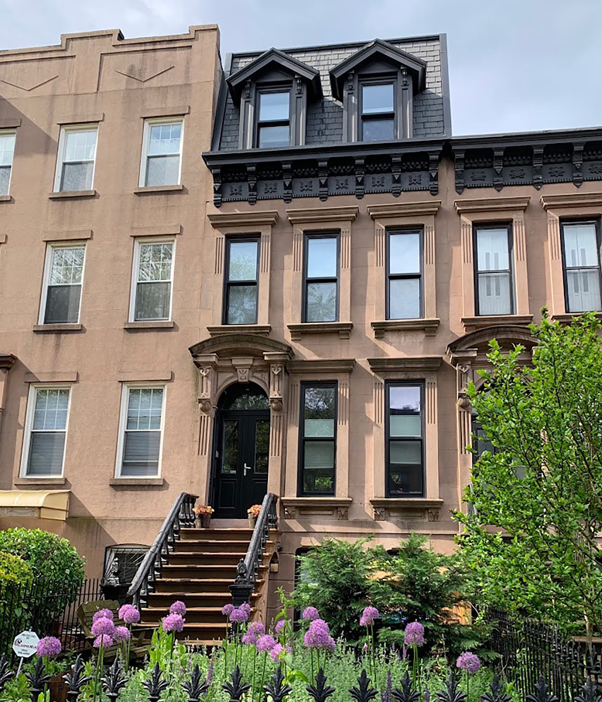 Front façade of a Carroll Gardens Passive House with a new full-story mansard addition with dormers.