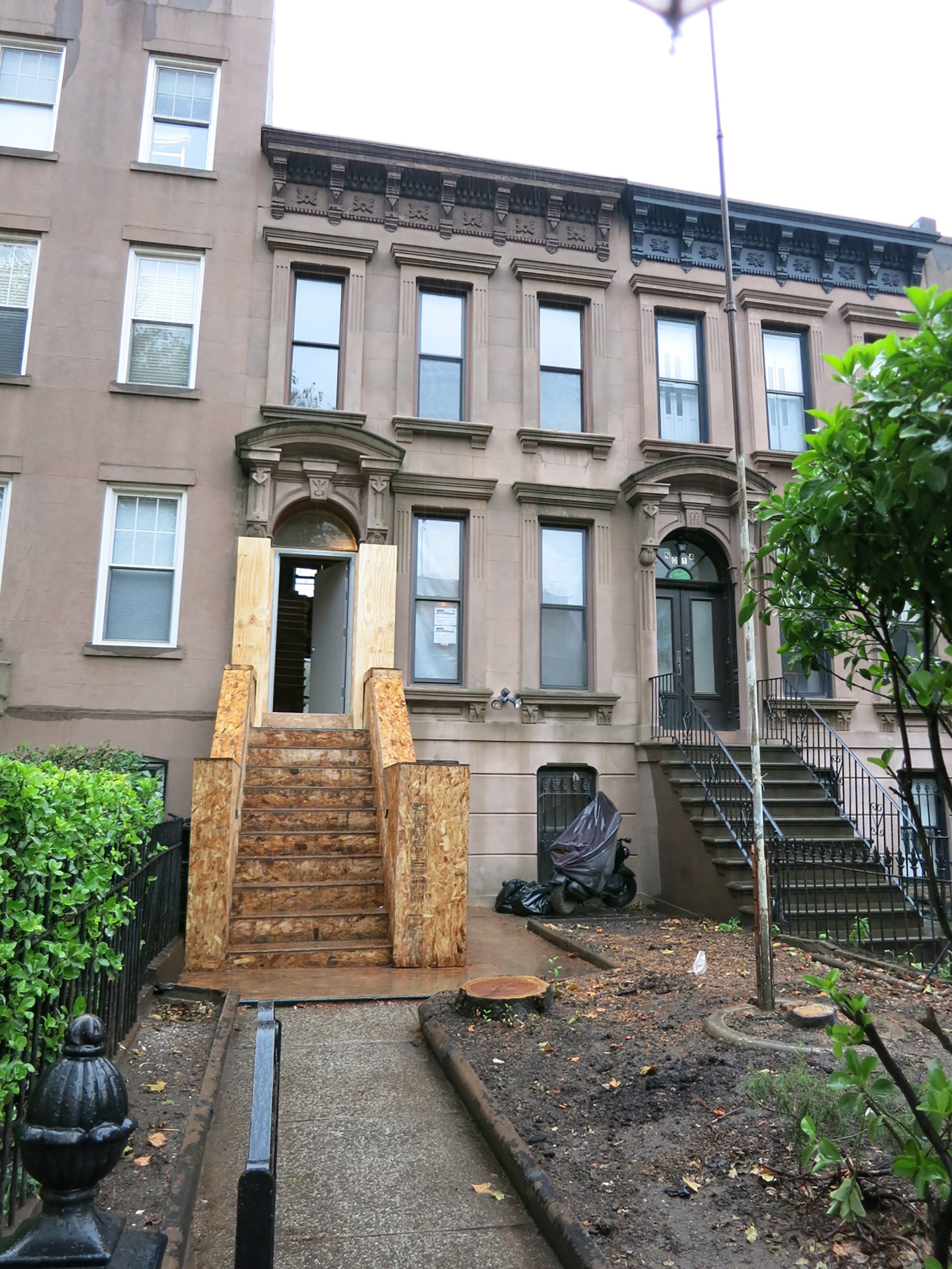 Front façade of a Carroll Gardens brownstone before our renovation, with the future stoop framed in plywood.