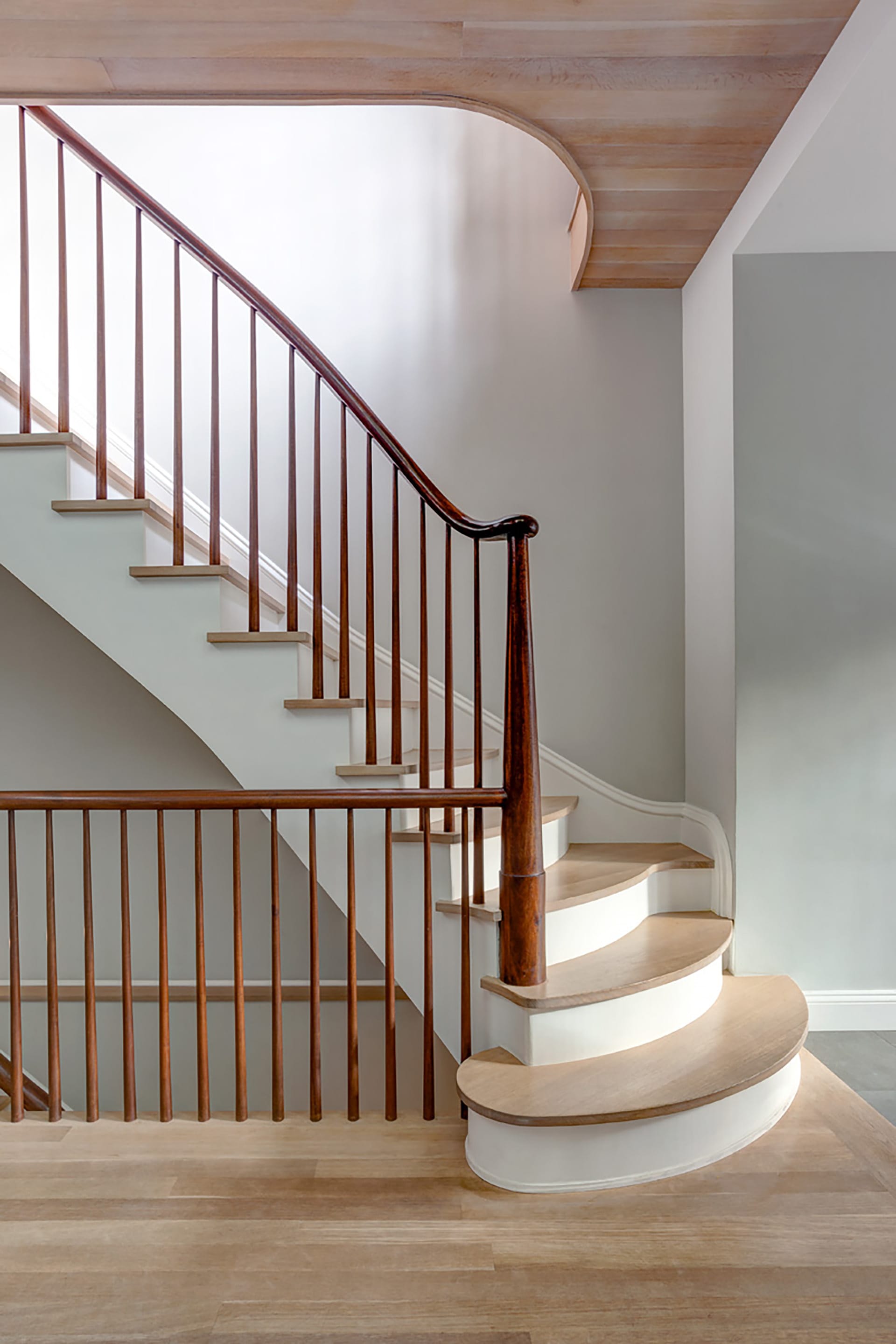 Close up of the first floor staircase in a Carroll Gardens home with light wood risers and dark wood posts and railings.