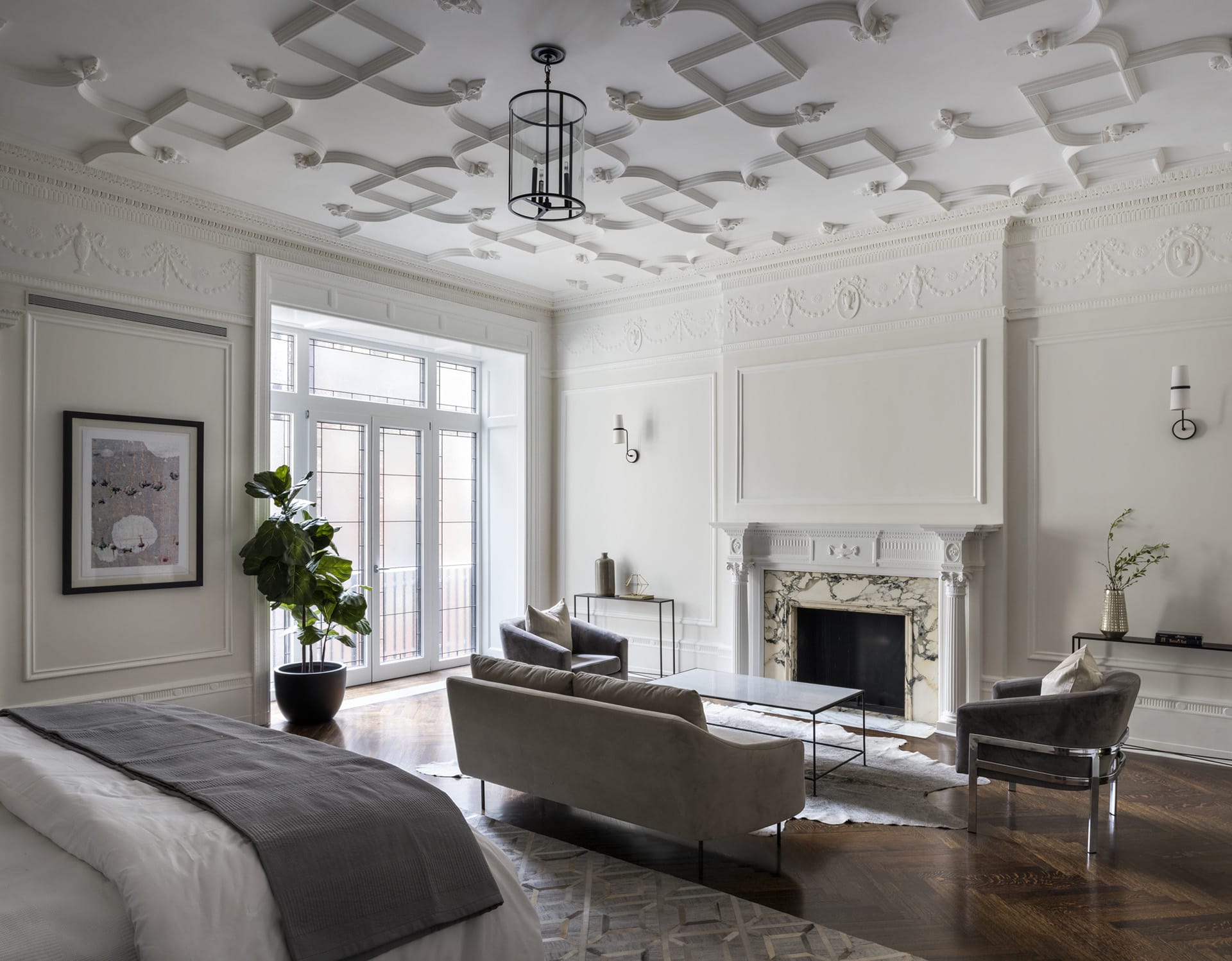 Bedroom with intricate plaster detailing on the crown and ceiling, marble fireplace, and restored historic windows.