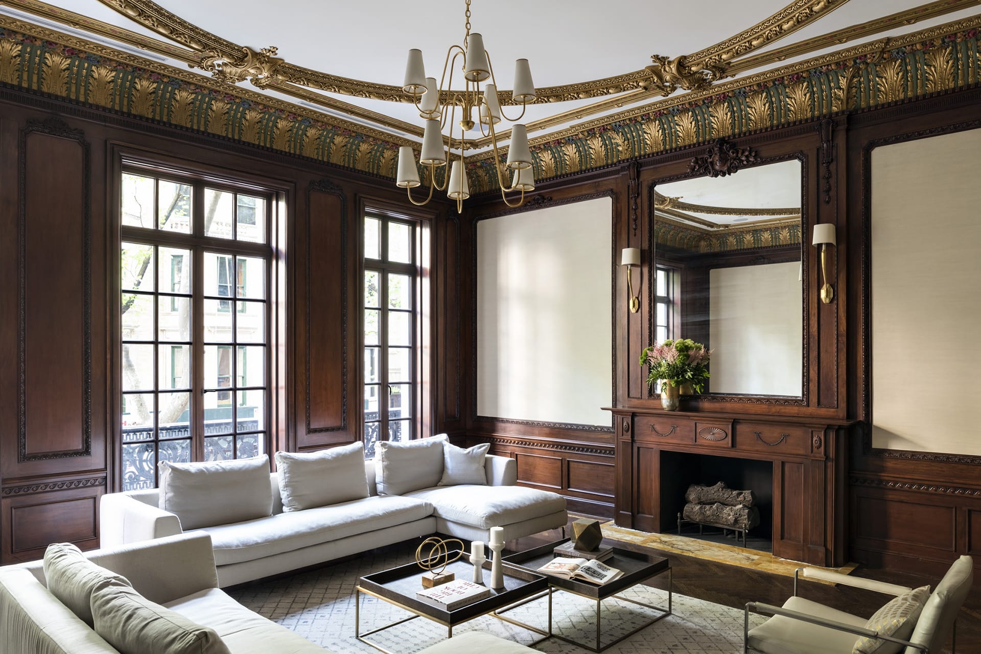 Living room with wood paneling, contemporary furnishings, and gold detailing on the ceiling and crown molding