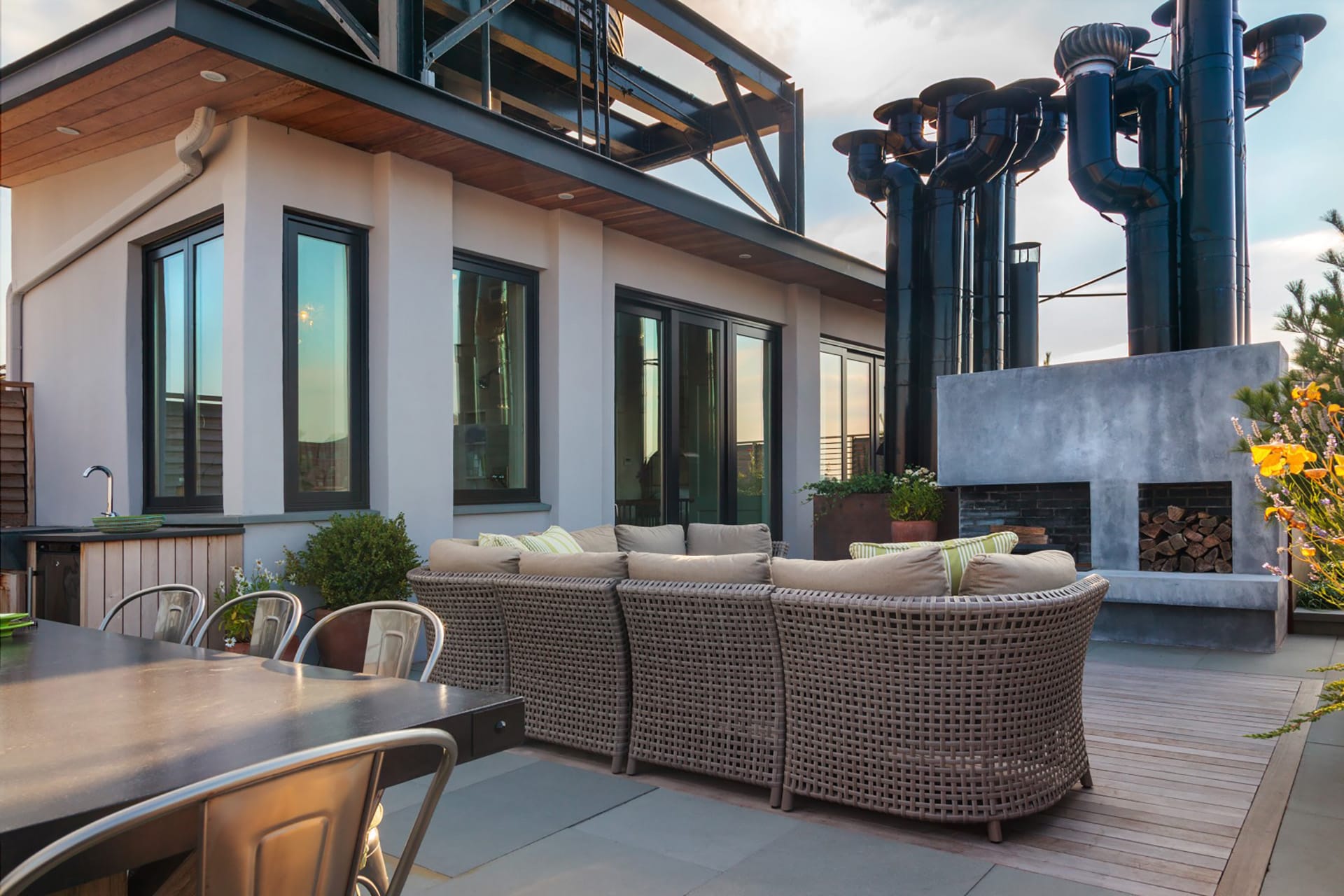 Roof deck with an outdoor seating area, kitchen, and wood-burning fireplace.