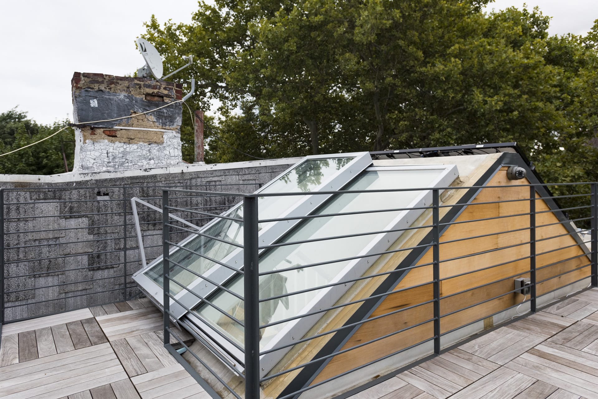 Glazed roof hatch on a Greenpoint roof deck with black railings